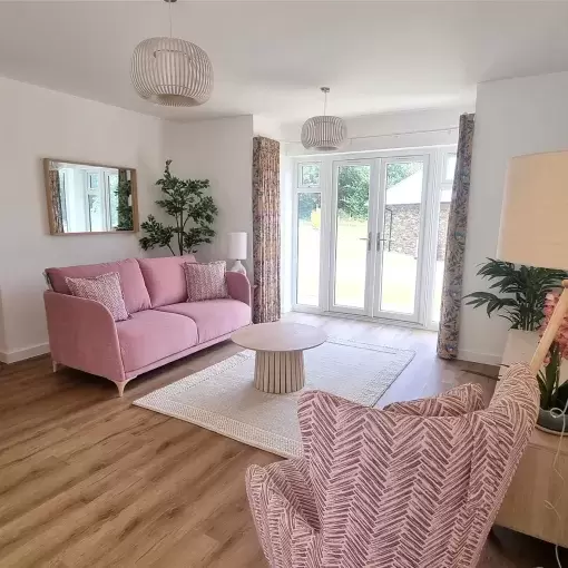 Spacious lounge with light pouring in from french doors